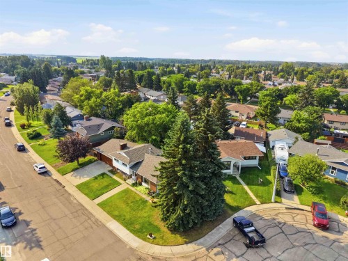 Aerial view showcasing a corner-lot property with mature landscaping, established trees, and manicured lawn - 30 Cavanagh Crescent, Stony Plain, AB - Outdoor With View