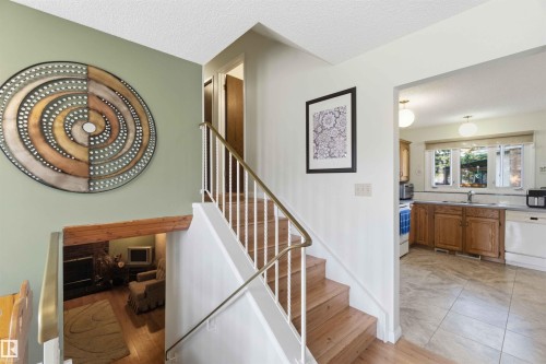 Wood-finish staircase with white risers and brass-toned handrails - 30 Cavanagh Crescent, Stony Plain, AB - Indoor Photo Showing Other Room