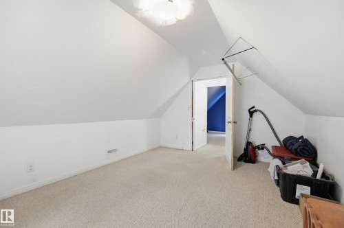 Carpeted room featuring a sloped ceiling, white walls, and a recessed ceiling light fixture - 10714 103 Street Nw, Edmonton, AB - Indoor Photo Showing Other Room