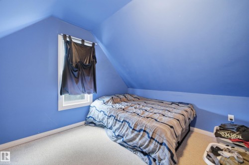 Room featuring sloped ceilings, a single window with white trim, and light-colored carpeting - 10714 103 Street Nw, Edmonton, AB - Indoor Photo Showing Bedroom