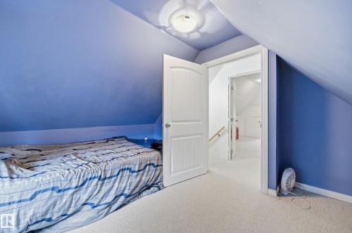 Carpeted room with sloped ceilings and a white paneled door - 10714 103 Street Nw, Edmonton, AB - Indoor Photo Showing Bedroom