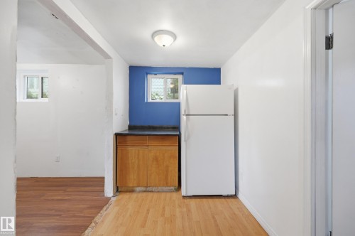 Kitchenette featuring wood cabinetry, a dark countertop, and a white refrigerator - 10714 103 Street Nw, Edmonton, AB - Indoor Photo Showing Other Room