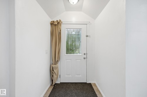 Front entry with a white paneled door featuring decorative glass - 10714 103 Street Nw, Edmonton, AB - Indoor Photo Showing Other Room