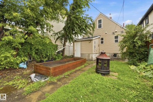 Backyard space featuring a raised planter box, mature trees, and a concrete path - 10714 103 Street Nw, Edmonton, AB - Outdoor