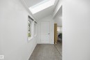 Entryway featuring a skylight, white paneled door, three windows, and light gray flooring - 10714 103 Street Nw, Edmonton, AB  - Indoor Photo Showing Other Room 