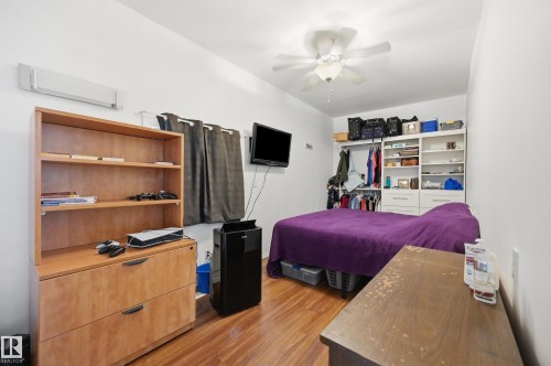 Room featuring wood-finish flooring and a white ceiling fan - 10714 103 Street Nw, Edmonton, AB - Indoor Photo Showing Bedroom