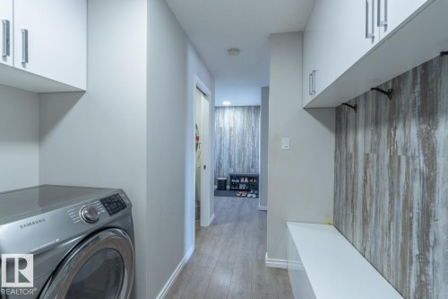 Hallway with wood-finish flooring and light gray walls - 1724 27 Street Nw, Edmonton, AB - Indoor Photo Showing Laundry Room