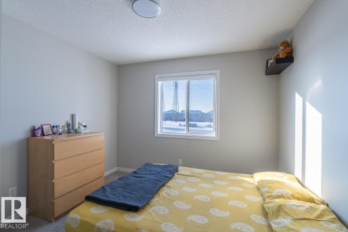 Bedroom featuring a large window, neutral wall paint, and gray carpet flooring - 1724 27 Street Nw, Edmonton, AB - Indoor Photo Showing Bedroom