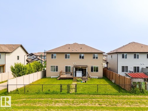 Rear exterior featuring a wood deck, manicured lawn, and perimeter fencing - 1724 27 Street Nw, Edmonton, AB - Outdoor With Deck Patio Veranda With Exterior