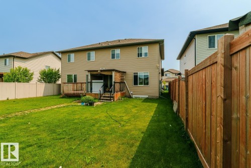 Expansive rear yard featuring a wood-decked patio with stairs, a privacy wall, and direct access to the interior - 1724 27 Street Nw, Edmonton, AB - Outdoor With Deck Patio Veranda With Exterior