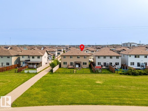 Rear exterior featuring a deck, fenced yard, and direct access to a paved pathway - 1724 27 Street Nw, Edmonton, AB - Outdoor