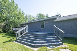 Multi-level wood deck featuring a landing, staircase with handrails, and a perimeter railing - 