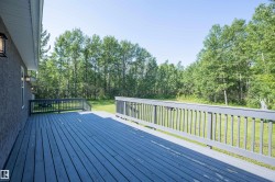 Expansive outdoor deck featuring composite decking, painted railings, and exterior wall sconces - 