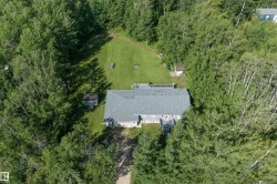 Expansive property featuring a grey shingle roof, a rear deck, and a detached shed - 