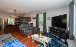 Open-concept living space with wood-finish flooring - 