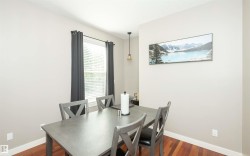 Dining area featuring rich wood-finish flooring and neutral wall tones - 