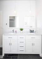 Dual vanity with white shaker cabinetry, stone countertop, two undermount sinks, and chrome fixtures - 