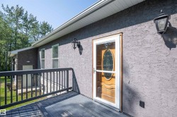 Textured stucco exterior with a durable wood-finish deck and black railing - 