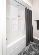 White fiberglass tub and shower combination with integrated shelving - 