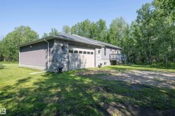 Exterior with a stone facade accent, light gray siding, and a two-car garage - 