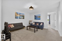 Carpeted room with light gray walls, featuring a white interior door with bright white trim and a ceiling-mounted light fixture - 