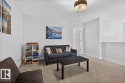 Carpeted room with a ceiling-mounted light fixture, white walls, and a visible doorway with a white panel door - 