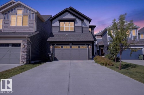 Two-story residence featuring a dark gray facade with contrasting siding accents, an attached two-car garage, and a concrete driveway - 3805 Cherry Loop Sw, Edmonton, AB - Outdoor With Facade