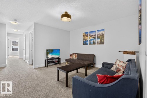 Carpeted living area featuring white walls and a white textured ceiling - 3805 Cherry Loop Sw, Edmonton, AB - Indoor Photo Showing Other Room