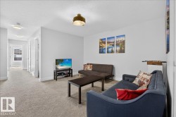 Carpeted living area featuring white walls and a white textured ceiling - 