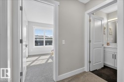 Hallway with light gray walls, white trim, and carpet flooring - 