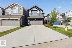 Contemporary two-story residence with a concrete driveway and attached garage - 