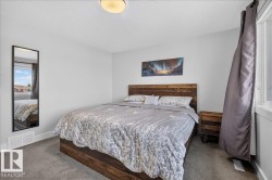 Bedroom featuring neutral wall paint, gray carpet flooring, and a large window with white trim - 