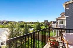 Second-story balcony featuring wood-finish decking and black metal railings - 