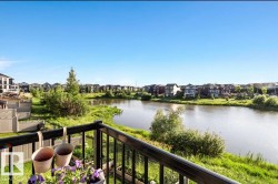 Balcony featuring black metal railings and a clear view of the water and residential area - 