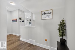 Entryway featuring wood-finish flooring, crisp white baseboards, and neutral wall tones - 