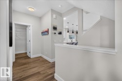 Hallway with wood-finish flooring, white baseboards, and a built-in closet - 