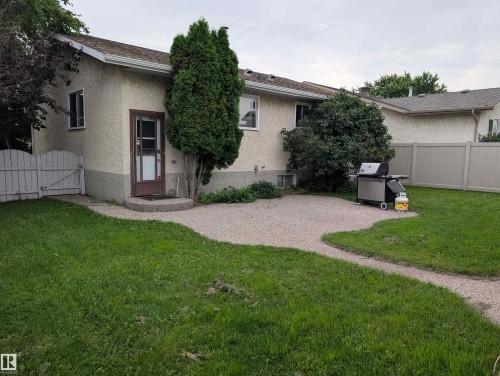 Expansive backyard featuring a manicured lawn, a gravel patio, and a privacy fence - 14228 22 Street Nw, Edmonton, AB - Outdoor