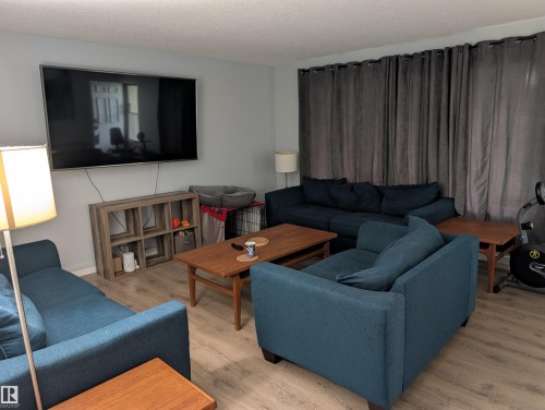 Living area featuring light gray wall paint and wood-finish flooring - 14228 22 Street Nw, Edmonton, AB - Indoor Photo Showing Living Room