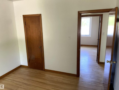 Room featuring wood-finish flooring, white painted walls, and wood trim - 11308 73 Avenue Nw, Edmonton, AB - Indoor Photo Showing Other Room
