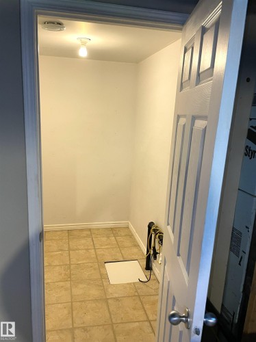 Utility space featuring tile flooring, white painted walls, and an overhead light fixture - 11308 73 Avenue Nw, Edmonton, AB - Indoor