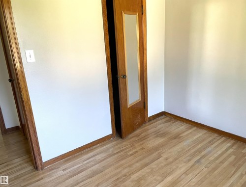 Hardwood-style flooring with natural wood-tone trim - 11308 73 Avenue Nw, Edmonton, AB - Indoor Photo Showing Other Room