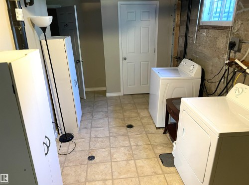 Laundry area featuring neutral-toned tile flooring, a white washing machine, and a white dryer - 11308 73 Avenue Nw, Edmonton, AB - Indoor Photo Showing Laundry Room