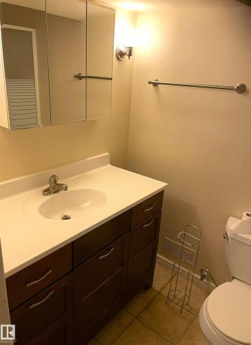Bathroom vanity featuring a white countertop with an integrated sink and a chrome faucet - 11308 73 Avenue Nw, Edmonton, AB - Indoor Photo Showing Bathroom