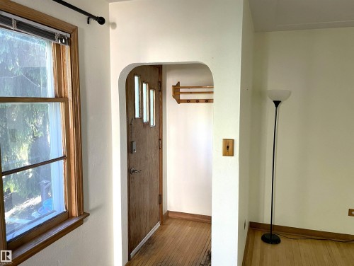 Entryway featuring a wood-finish door with glass panels, arched doorway, and hardwood flooring - 11308 73 Avenue Nw, Edmonton, AB - Indoor Photo Showing Other Room