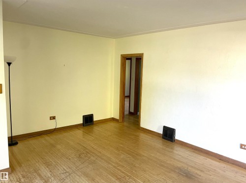 Spacious room featuring light-toned walls and wood-finish flooring - 11308 73 Avenue Nw, Edmonton, AB - Indoor Photo Showing Other Room