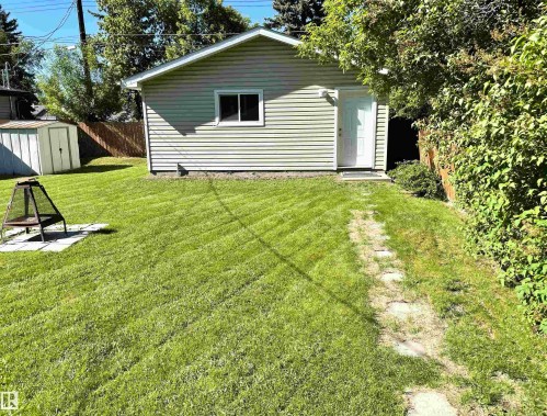 Detached garage with horizontal siding, a single window, and a white entry door - 11308 73 Avenue Nw, Edmonton, AB - Outdoor