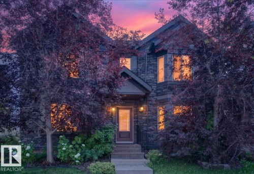 Stone-clad exterior featuring a prominent front entrance with an overhang and exterior lighting - 3043 Keswick Way Sw, Edmonton, AB - Outdoor