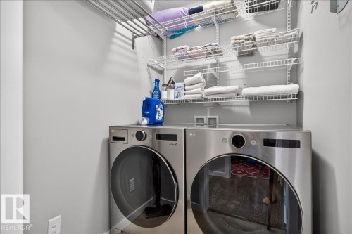 Stainless steel front-load washer and dryer pair with integrated controls - 3043 Keswick Way Sw, Edmonton, AB - Indoor Photo Showing Laundry Room