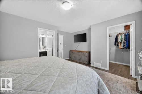 Soft gray wall paint with white trim, wood-finish flooring, and overhead lighting - 3043 Keswick Way Sw, Edmonton, AB - Indoor Photo Showing Bedroom