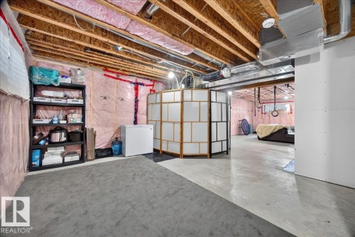 Unfinished basement space featuring exposed wooden joists, visible insulation, and concrete flooring - 3043 Keswick Way Sw, Edmonton, AB - Indoor Photo Showing Basement